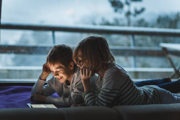istock Two happy brothers enjoying and relaxing while using digital tablet together 1188759371