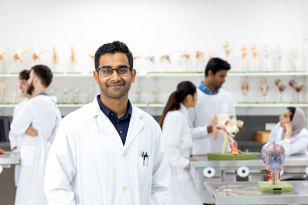 Portrait Of Young Indian Male Medical Student Portrait Of Young Indian Male Medical Student in University Lab Wearing Lab Coat anatomist photos stock pictures, royalty-free photos & images