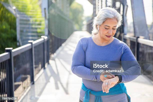 Mature Mexican Woman Using Fitness Tracker Stock Photo - Download Image Now - Fitness Tracker, Smart Watch, Wearable Computer