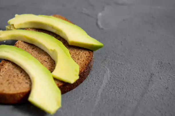 Homemade toast with avocado on concrete