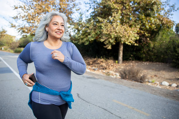 Mexican Woman Jogging A mature Mexican woman jogging on a trail cardiovascular exercise stock pictures, royalty-free photos & images