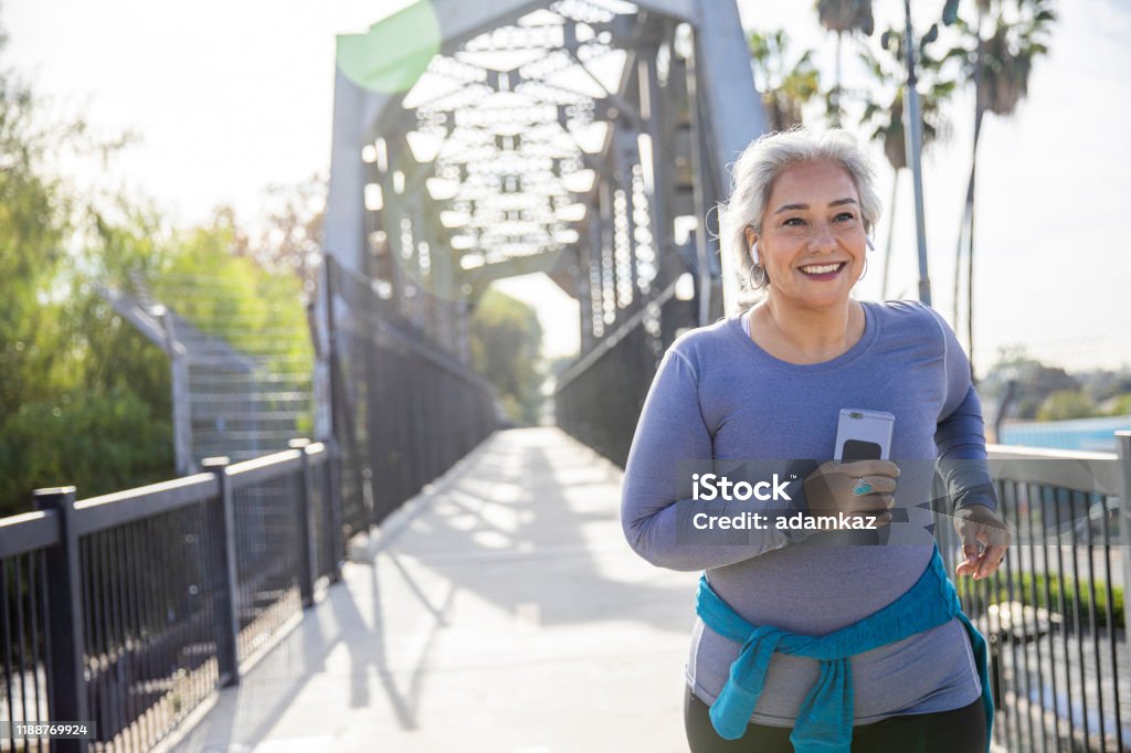 Mexican Woman Jogging on a Trail A mature Mexican woman jogging on a trail Healthy Lifestyle Stock Photo