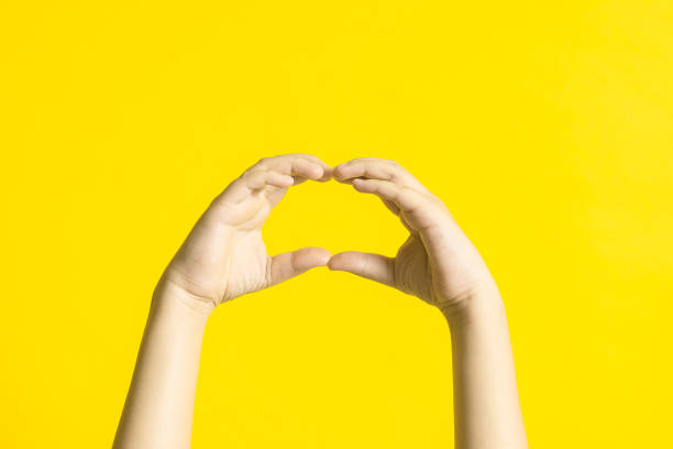 istock Kid's hands with sign language on yellow background. 1188782655