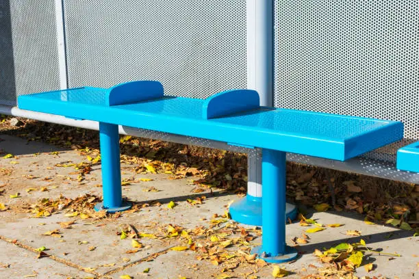 Armrest in the middle of bench to stop homeless people from sleeping, resting or lying down on the bench in public transportation passenger shelter