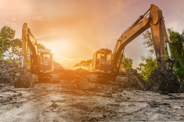 istock Backhoe to excavate the soil on the ground construction site at sunset 1188799299