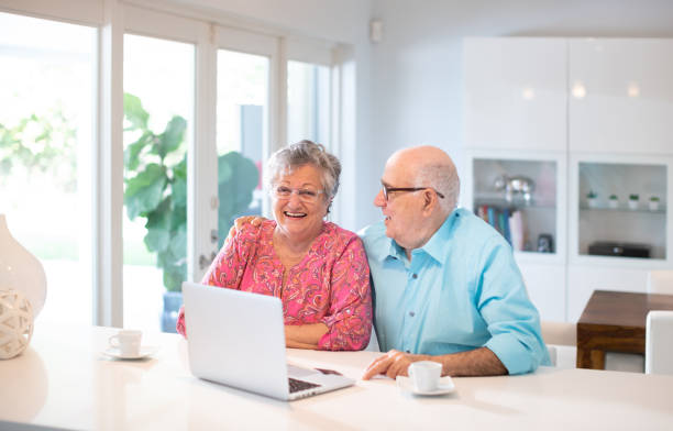 istock Happy latin senior couple in their kitchen using a laptop 1188799986