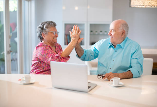 istock Happy latin senior couple in their kitchen using a laptop 1188800065