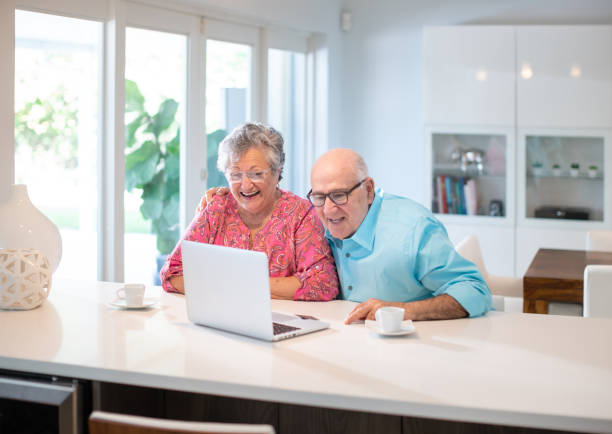 istock Happy latin senior couple in their kitchen using a laptop 1188800094
