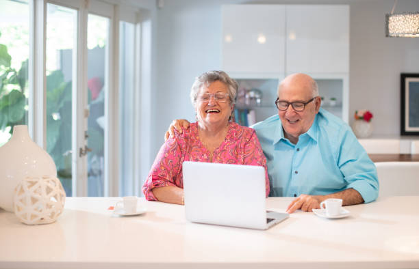 istock Happy latin senior couple in their kitchen using a laptop 1188800241
