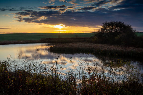 istock Vivid orange sunset reflected in a tranquil lake 1188805075