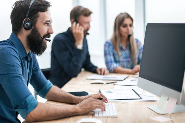 istock business man in a headset sitting at the office table 1188813822