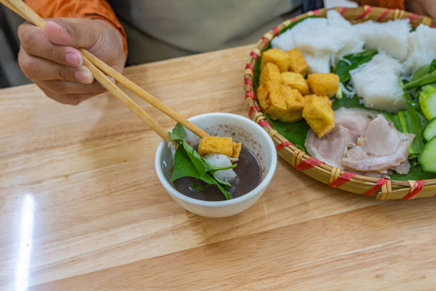 istock Woman using chopsticks eating fried tofu noodles and shrimp paste 1188819256