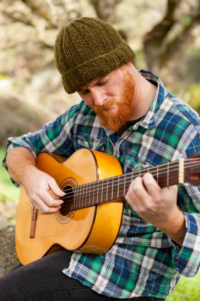 istock Hipster man with red beard playing a guitar 1188822207