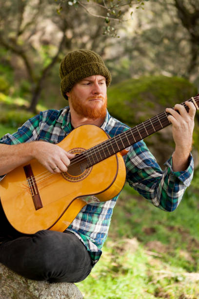 istock Hipster man with red beard playing a guitar 1188822211