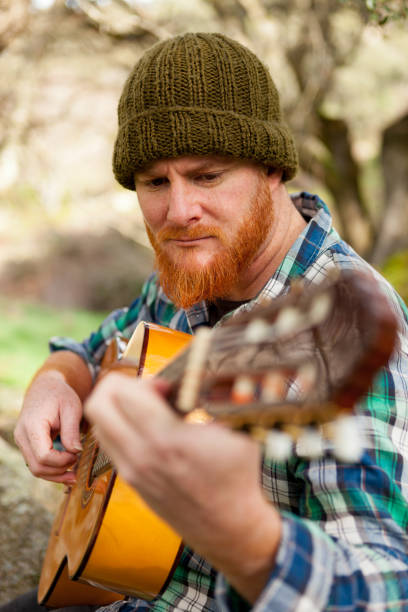 istock Hipster man with red beard playing a guitar 1188822215
