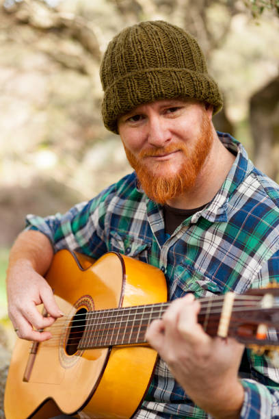 istock Hipster man with red beard playing a guitar 1188822217