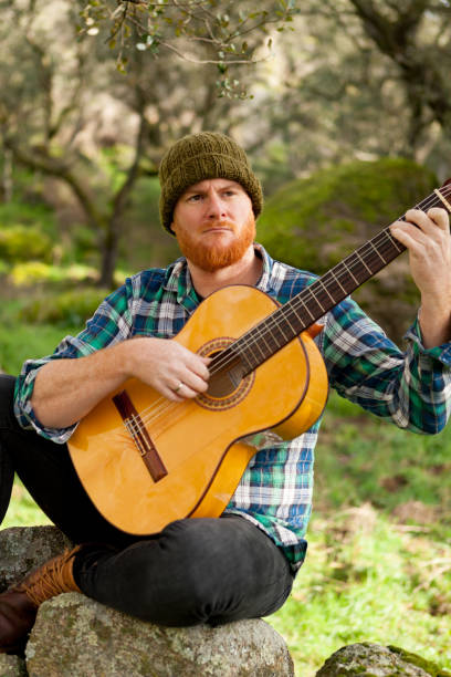 istock Hipster man with red beard playing a guitar 1188822220