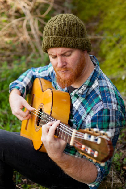 istock Hipster man with red beard playing a guitar 1188822280