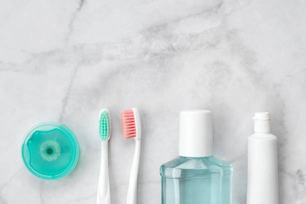 istock Set of pink and turquoise blue toothbrushes, toothpaste and other tools on marble background. Dental and health care concept. Top view, flat lay. Free copy space. 1188824493