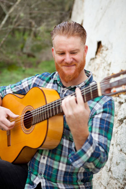 istock Hipster man with red beard playing a guitar 1188825119
