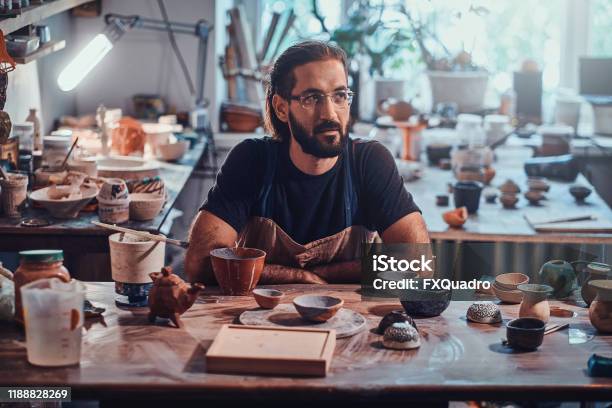 Happy Man In Glasses Is Sitting At His Owh Workshop And His Projects Are Around Him Stock Photo - Download Image Now