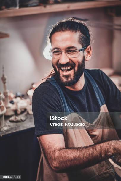 Charismatic Happy Man In Glasses Is Sitting At His Owh Workshop And His Projects Are Around Him Stock Photo - Download Image Now