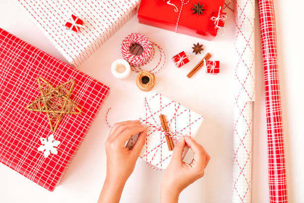 istock Woman's hands with christmas gift box with decorations on white background. 1188830107