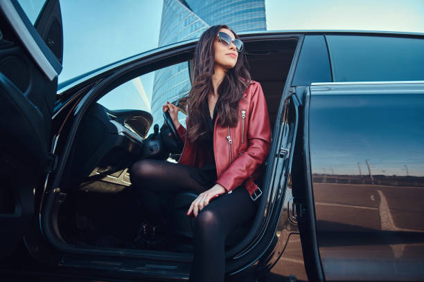 istock Young attractive women is posing in her new car 1188830480