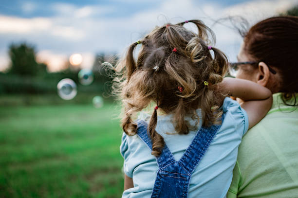 Mother and daughter looking away in nature.