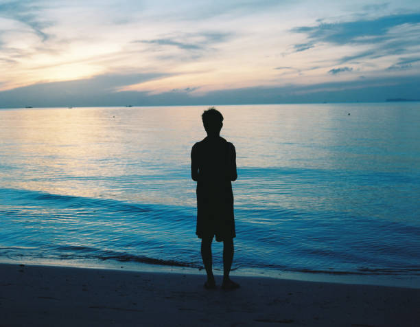 istock A man silhouette stand alone on beach 1188833225