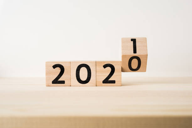 Business and design concept - surreal abstract geometric floating wooden cube with word 2020 and 2019 concept on wood floor and white background Business and design concept - surreal abstract geometric floating wooden cube with word 2021 and 2020 concept on wood floor and white background january photos stock pictures, royalty-free photos & images