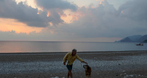istock Man walks along empty beach at sunrise 1188834266