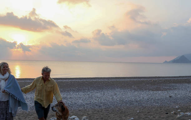 istock Couple walks along empty beach at sunrise 1188835487