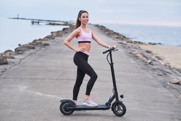 istock Pretty woman is driving her scooter by seashore 1188835538