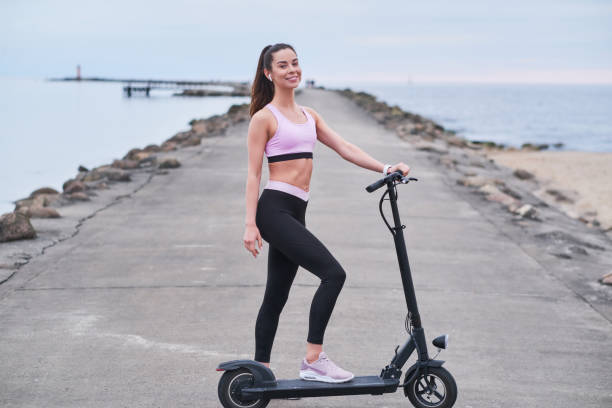 istock Pretty woman is driving her scooter by seashore 1188836662