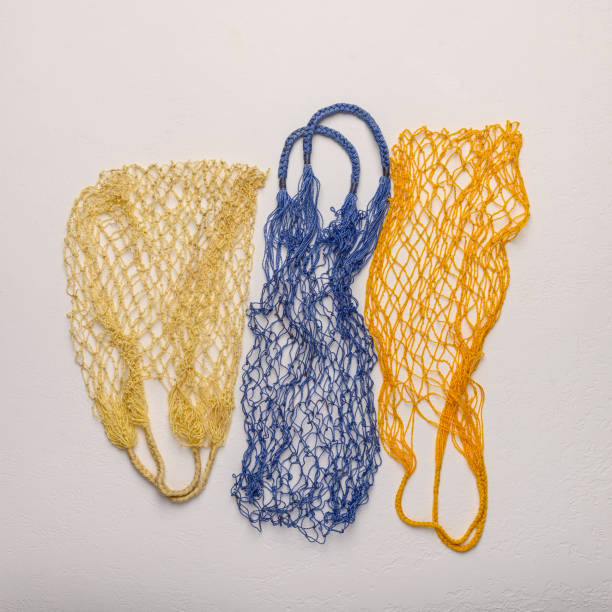 istock Concept of the three colored string bags made from natural materials on a light background. Environmental protection 1188839221