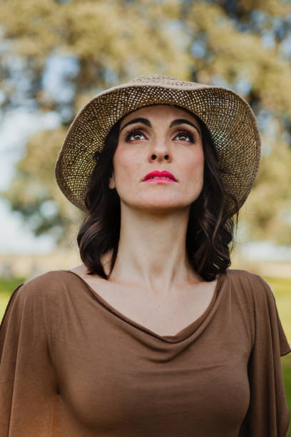 istock Stylish young woman with straw hat looking up 1188839401