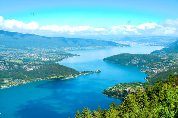 Beautiful landscape view of Annecy Lake from Col de la Forclaz the place for skydiver sport in sunny day with view blue ocean lake, mountain, forest, white cloud and blue sky. stock photo