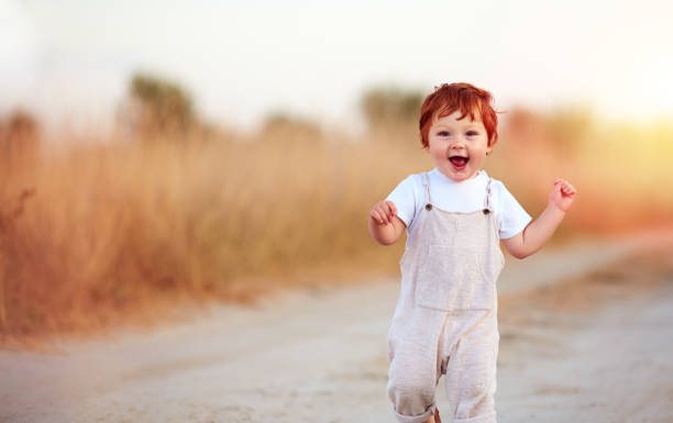 istock adorable redhead baby boy running the summer path 1188842542