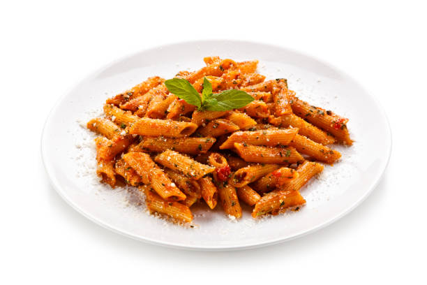 istock Penne with pork, sauce and vegetables on white background 1188842871