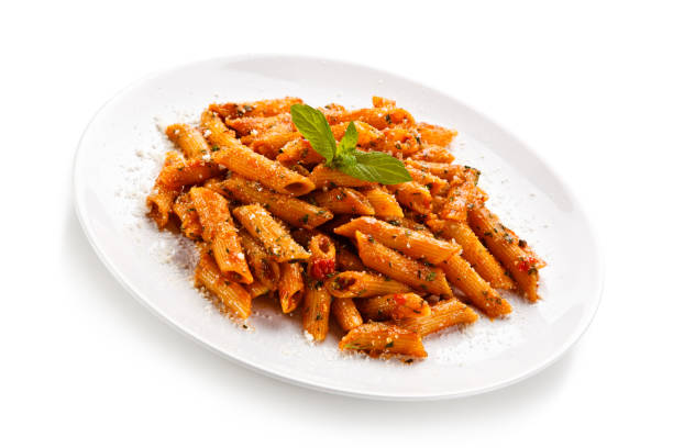 istock Penne with pork, sauce and vegetables on white background 1188842934