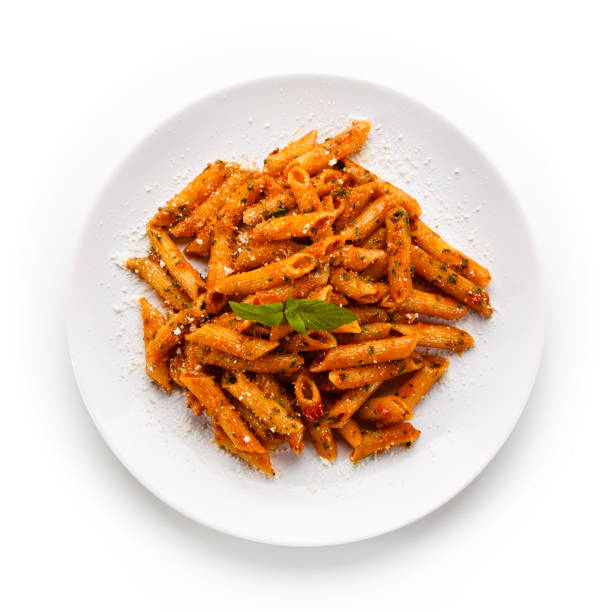 istock Penne with pork, sauce and vegetables on white background 1188843563