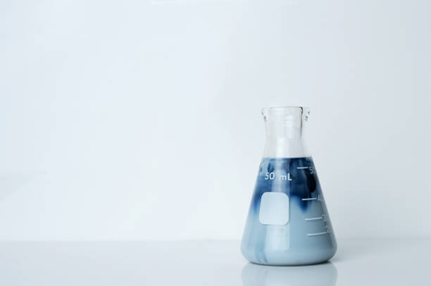 single creamy opaque blue green solution in science glass flask in chemistry laboratory background