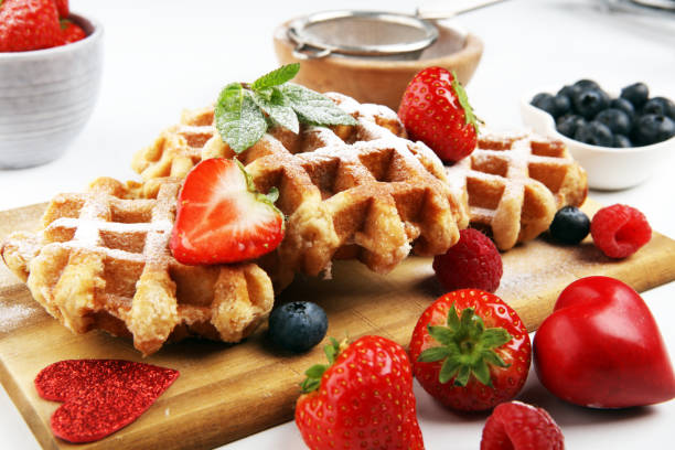 istock Traditional belgian waffles with fresh blueberries, sugar and raspberries on rustic table 1188845299