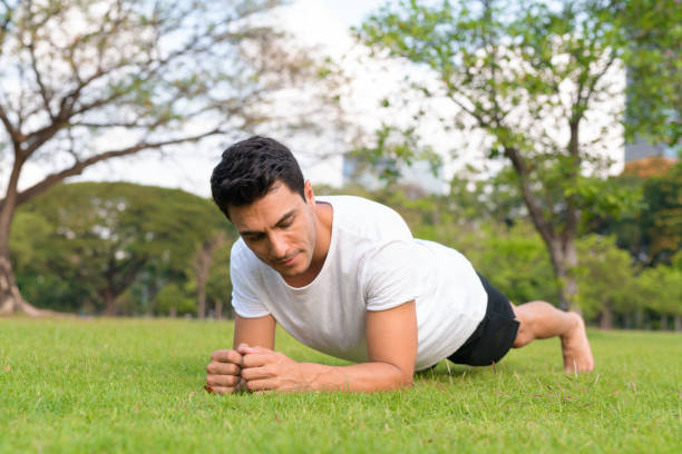 istock Young handsome Hispanic man doing plank exercise in the park 1188845670