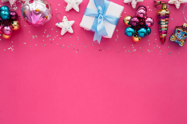 Christmas composition. Beautiful toys, gifts and candy on the pink background. stock photo