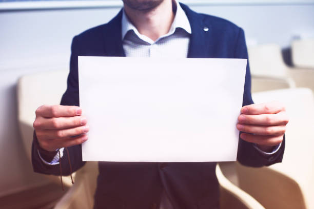 istock Young businessman holding blank page. 1188847087