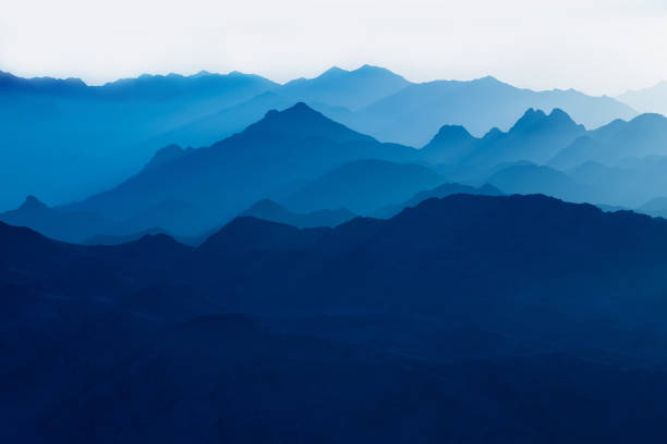 istock Beautiful view from the mountain. Panorama. Mountain range with visible silhouettes through the morning blue fog 1188848694