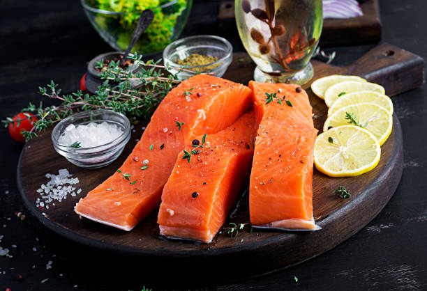 istock Raw salmon fillet and ingredients for cooking on a dark background in a rustic style. 1188850148