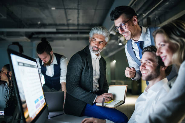 istock A group of business people in an office at night, using computer. 1188852275